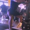 Aluno realizando agachamento sumô, ressaltando a importância do treino de pernas em relação a simetria corporal.